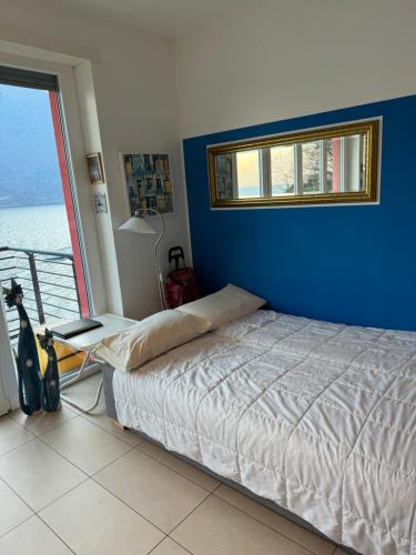 a bedroom with a bed and a blue wall at a...fior di lago in Abbadia Lariana