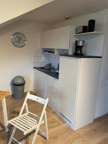 a kitchen with a white refrigerator and a chair at Stadtrand Oase Appartement in Spenge