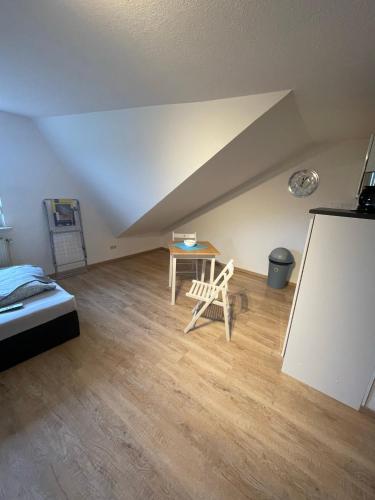 a room with a bed and a table in a attic at Stadtrand Oase Appartement in Spenge