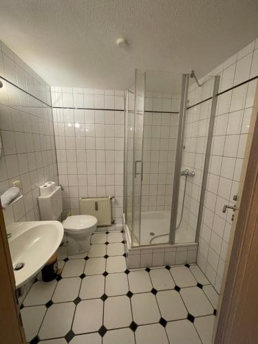 a bathroom with a shower and a toilet and a sink at Stadtrand Oase Appartement in Spenge