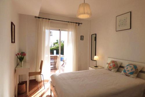 ein Schlafzimmer mit einem Bett und einem Tisch mit einer Lampe in der Unterkunft Selecta Casa Blanca Estepona in Estepona