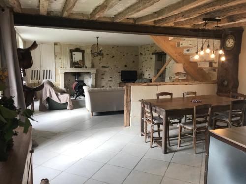 un salon avec une table et un canapé dans l'établissement Maison de charme à la campagne, à Cersay
