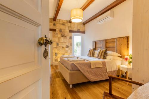 a bedroom with a bed and a stone wall at Ginevra Home in Monterosi