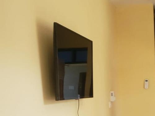 a flat screen tv hanging on a wall at Bella Breeze2 -Diani Beach Kenya in Diani Beach