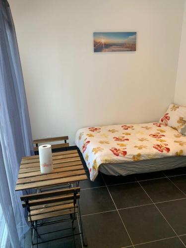 - une chambre avec un lit et une table en bois dans l'établissement 3 jolies pavillons type studio, à Nancy