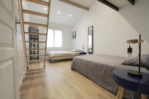 a bedroom with a bed and a desk and a ladder at Orly Serenity House Paris 20min Aéroport 12min Parking gratuit in Orly