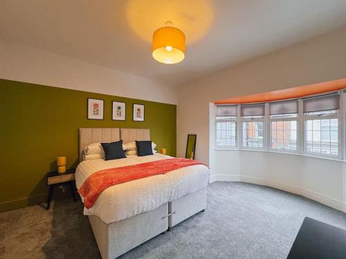 a bedroom with a large bed with green walls at Vibrant Tranquility: What a gem! in Cleethorpes