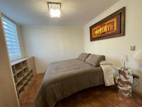 a bedroom with a bed and a painting on the wall at Depto para 2 a 4 personas in Curicó