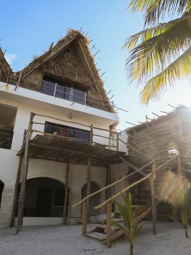 a house on the beach with a thatch roof at Casa Mate BeachFront HOUSES El Cuyo in El Cuyo