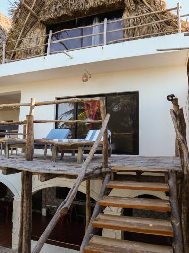 a deck of a house with a thatched roof at Casa Mate BeachFront HOUSES El Cuyo in El Cuyo