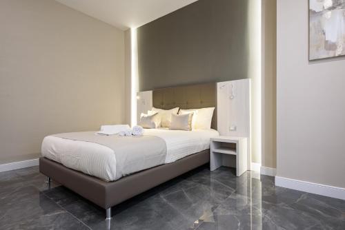 Un dormitorio con una gran cama blanca en una habitación. en DEDA & FOVE, en Nápoles