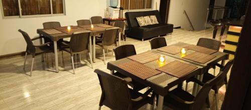Hotel Palo Grande في مانيزاليس: مطعم فيه طاولات وكراسي عليها شماعات