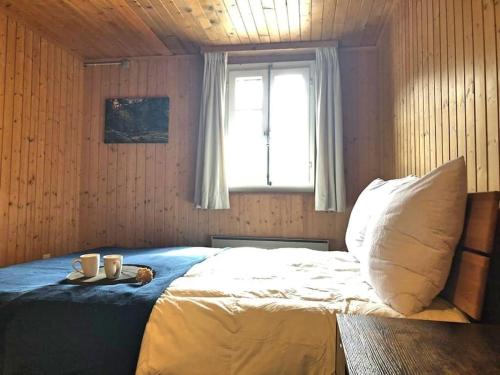 um quarto com uma cama com duas canecas em Cosy mountain apartment 5min walk from Gondola em Fiesch