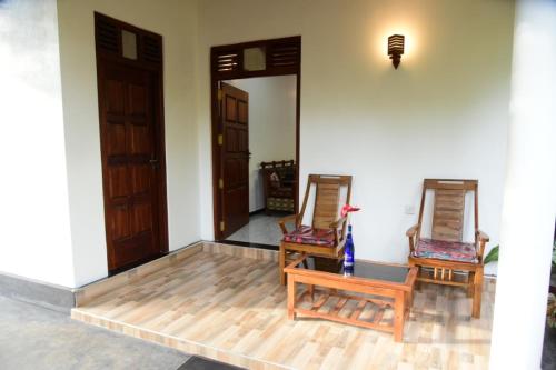two chairs and a table in a room at Sanjee Villa Hikkaduwa in Hikkaduwa