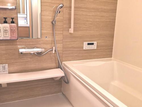 ein Badezimmer mit einer Badewanne und einem Waschbecken in der Unterkunft KIK HOUSE-Self Check in- Will send room number and password in Tokio