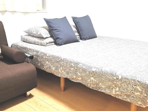 Bett mit Kissen darauf in einem Zimmer in der Unterkunft KIK HOUSE-Self Check in- Will send room number and password in Tokio