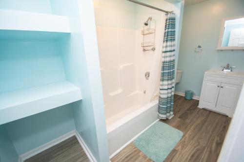 a bathroom with a white tub and a sink at Cresent Beach House by Palmetto Vacation Rentals in Myrtle Beach