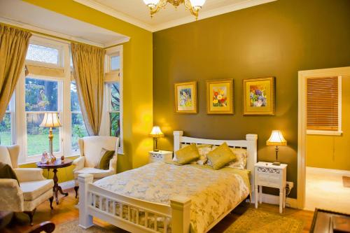 a yellow bedroom with a bed and a chair at Willowlodge in Scottsdale
