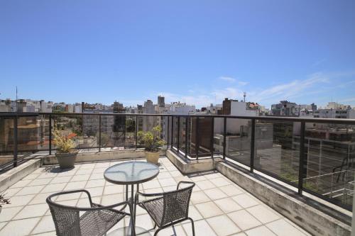 a patio with a table and chairs on a balcony at Punta Trouville Hotel in Montevideo