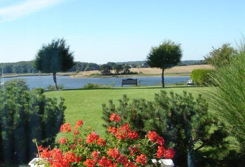 a park with a bench next to a body of water at Fischreiher 2 in Kappeln
