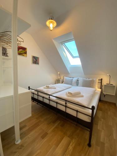 een slaapkamer met een bed en een dakraam bij ElegantLiving Graz, free parking in Graz