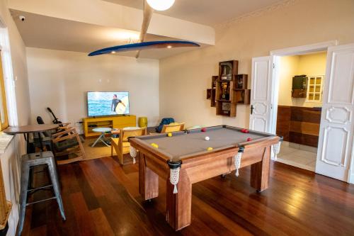 a living room with a pool table in it at Longboard Paradise Surf Club in Rio de Janeiro