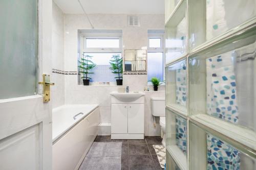 uma casa de banho com um lavatório, uma banheira e um WC. em UKSAS Two bed house Free Parking em Redbridge