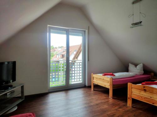 a attic room with a bed and a sliding glass door at das Apartmenthaus in Freiburg in Freiburg im Breisgau