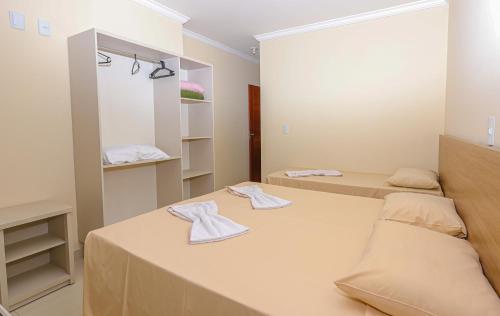 um quarto com três camas e um espelho em Residencial João e Maria - Aptos 03 quartos em Porto Seguro