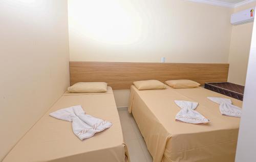 duas camas num quarto com toalhas em Residencial João e Maria - Aptos 03 quartos em Porto Seguro
