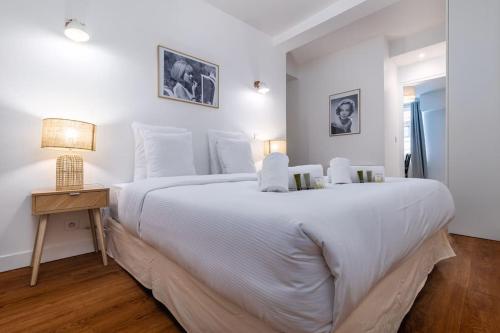 une chambre blanche avec un grand lit et une table dans l'établissement Lovely apartment in Paris - Saint germain des prés, à Paris