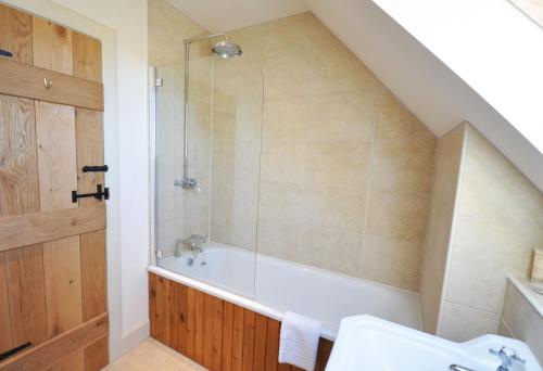 a bathroom with a shower and a bath tub at Old Mill Cottage in Kelso