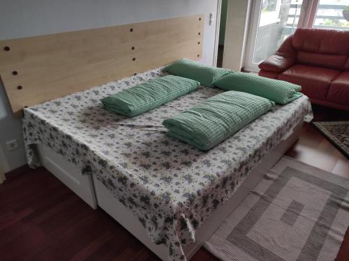 een bed met twee groene kussens erop bij Apartment Santana 59 mit Aufzug und Balkon in Radevormwald