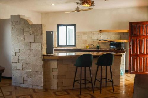 a kitchen with two bar stools at a counter at Casa Mate BeachFront HOUSES El Cuyo in El Cuyo
