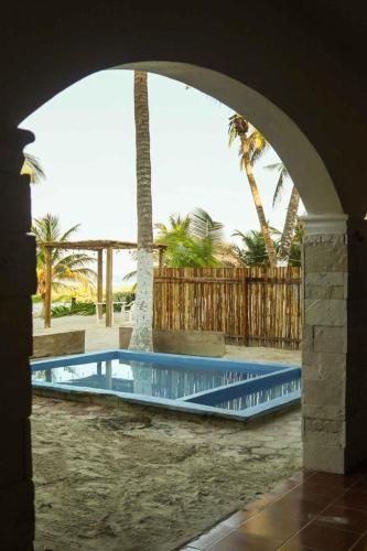 a swimming pool with an archway in a resort at Casa Mate BeachFront HOUSES El Cuyo in El Cuyo