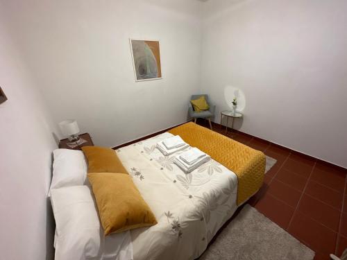 a small bedroom with a bed with a yellow blanket at Casa da Avó Ilda in Miranda do Douro