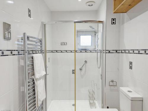 uma casa de banho branca com um chuveiro e um WC. em Holly House - Rustington em Rustington