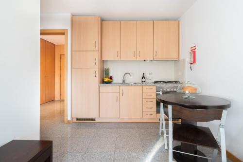 a kitchen with wooden cabinets and a black table at Host Wise - Comfy Charming Flat w Netflix - Ace Location in Porto