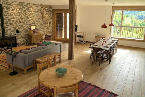 a living room with a couch and tables and a stone wall at Spacieux Chalet Authentique dans les 3 Vallées in Saint-Marcel