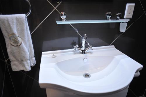 a bathroom with a white sink and towels at Hotel Destiny in Ongwediva