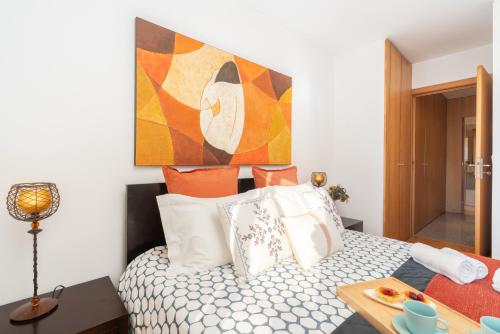 a bedroom with a bed with a painting on the wall at Host Wise - Comfy Charming Flat w Netflix - Ace Location in Porto