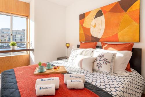 a bedroom with a bed with a tray of food on it at Host Wise - Comfy Charming Flat w Netflix - Ace Location in Porto