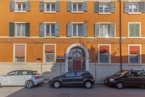 two cars parked in a parking lot in front of a building at Dimora Storica Manfredini nel cuore di Ferrara in Ferrara