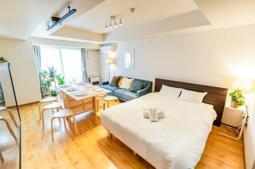 a bedroom with a bed and a dining room at 今年新規OP 最大9人 すすきのエリア 札幌観光に抜群の立地 空港直通バス停すぐ 高速Wi-Fi完備 in Sapporo