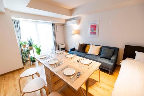 a living room with a table and a couch at 今年新規OP 最大9人 すすきのエリア 札幌観光に抜群の立地 空港直通バス停すぐ 高速Wi-Fi完備 in Sapporo