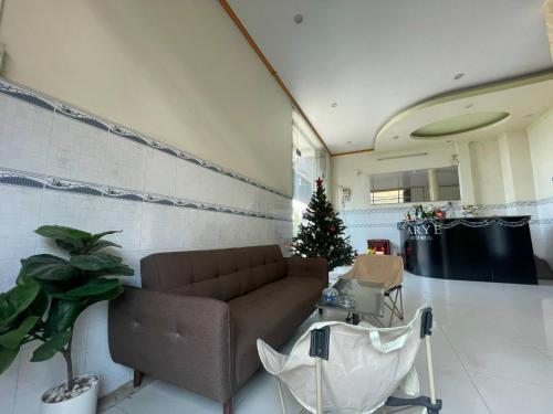 ein Wohnzimmer mit Sofa und Weihnachtsbaum in der Unterkunft ARYE guest house in Ấp Lợi Ðủ