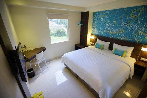 a bedroom with a large white bed and a desk at Meize City Center Bandung in Bandung