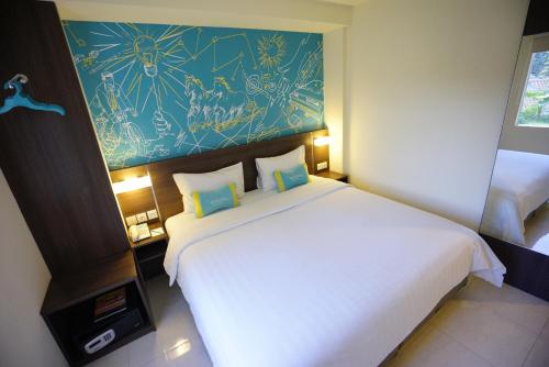 a bedroom with a large white bed and a painting on the wall at Meize City Center Bandung in Bandung