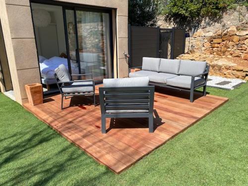 d'une terrasse avec un canapé et deux chaises. dans l'établissement Le jardin de Flo à Bandol, à Bandol