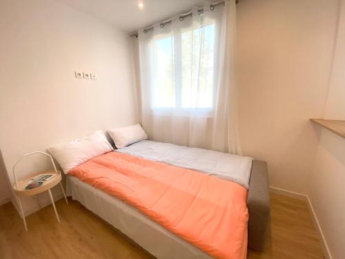 a small bed in a room with a window at Appart Laffitte joli T2 au coeur du parc & parking & RER pour Paris & La Défense in Maisons-Laffitte